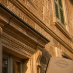Modénature en pierre : relief sculpté et lumière dorée sur une façade